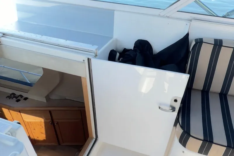 Chasing Sunsets Yacht Photos Pics Interior view of 2000 Pacific Mariner 65 Motoryacht with striped seating and wooden cabinets.