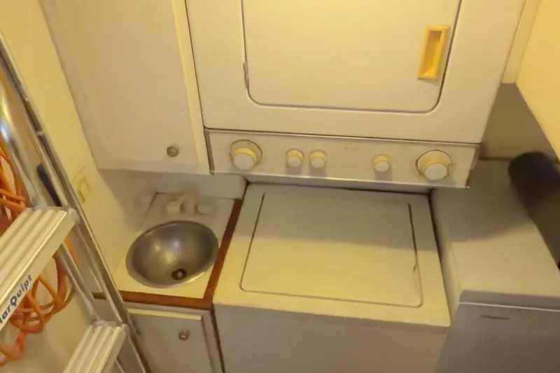 Chasing Sunsets Yacht Photos Pics Laundry area in 2000 Pacific Mariner 65 Motoryacht with washer, dryer, and sink.