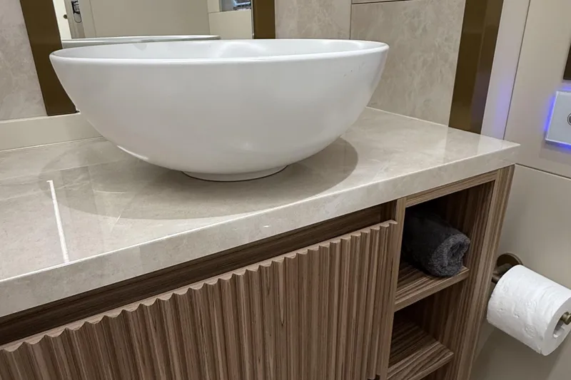 Explocean 3 Yacht Photos Pics Modern bathroom sink with marble countertop and wooden cabinet, Explorer 62, 2025 model.