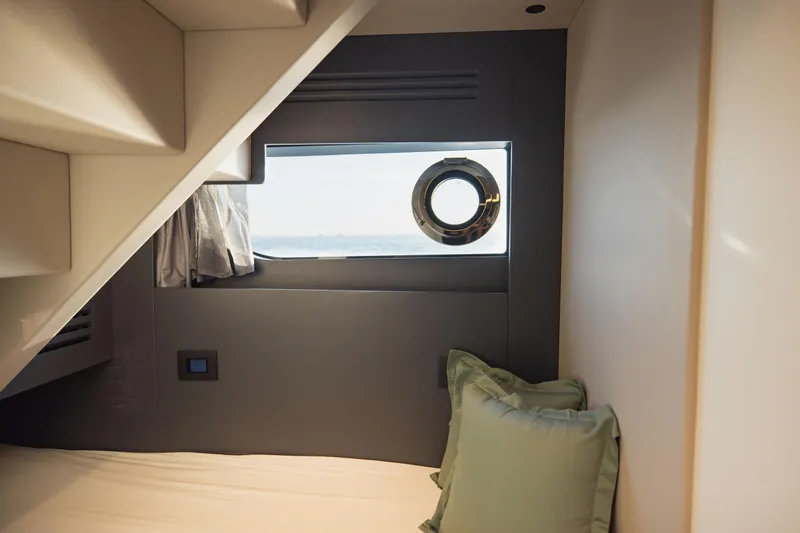 Explocean 3 Yacht Photos Pics Cozy cabin interior of 2025 Explorer 62 yacht with porthole and pillows.