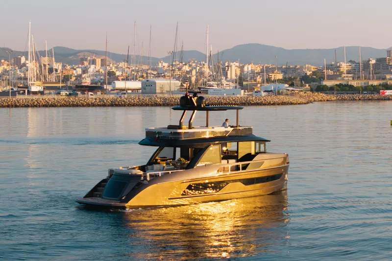 Explocean 3 Yacht Photos Pics 2025 Explorer 62 yacht cruising in a sunlit harbor with cityscape backdrop.