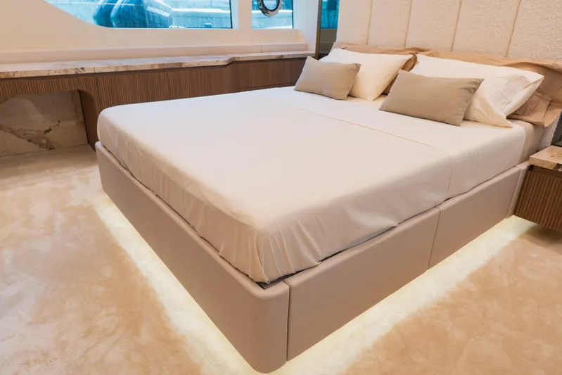 Explocean 3 Yacht Photos Pics Luxurious bedroom interior on 2025 Explorer 62 yacht, featuring elegant bed and ambient lighting.