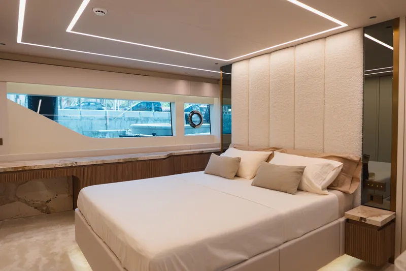 Explocean 3 Yacht Photos Pics Luxurious bedroom interior on 2025 Explorer 62 yacht, featuring modern design and large window.