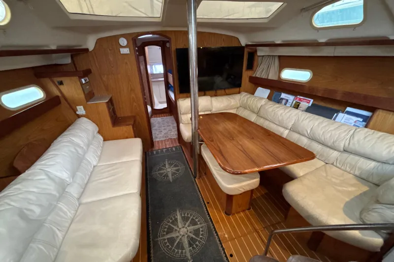 Kraken Yacht Photos Pics Interior of 2000 Hunter Passage 450 yacht with cozy seating and wooden table.