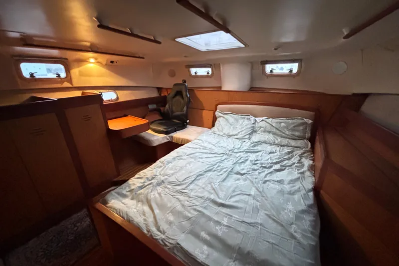 Kraken Yacht Photos Pics Cozy cabin interior of 2000 Hunter Passage 450 sailboat with bed and seating area.