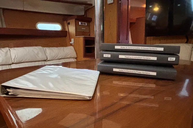 Kraken Yacht Photos Pics Interior of 2000 Hunter Passage 450 yacht with manuals on a wooden table.