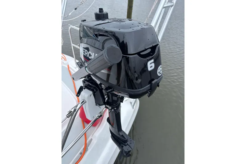 Kraken Yacht Photos Pics Outboard motor on 2000 Hunter Passage 450 sailboat, docked on calm water.