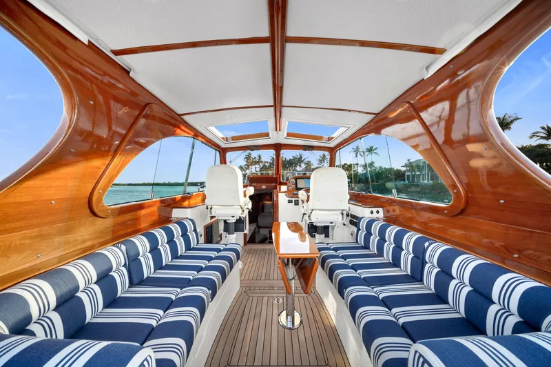 Midnight Yacht Photos Pics Luxurious 2014 Hinckley Picnic Boat 37 MKIII interior with striped seating and wooden finishes.
