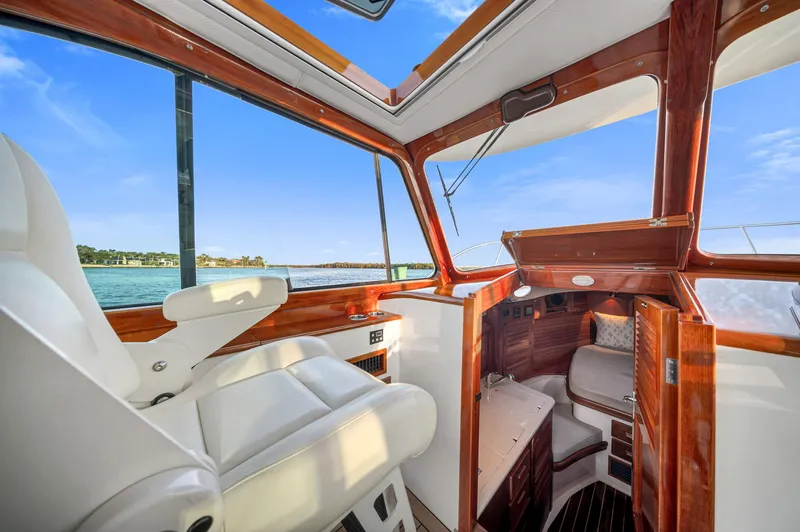 Midnight Yacht Photos Pics 2014 Hinckley Picnic Boat 37 MKIII interior with luxurious seating and wood finish, overlooking serene waters.