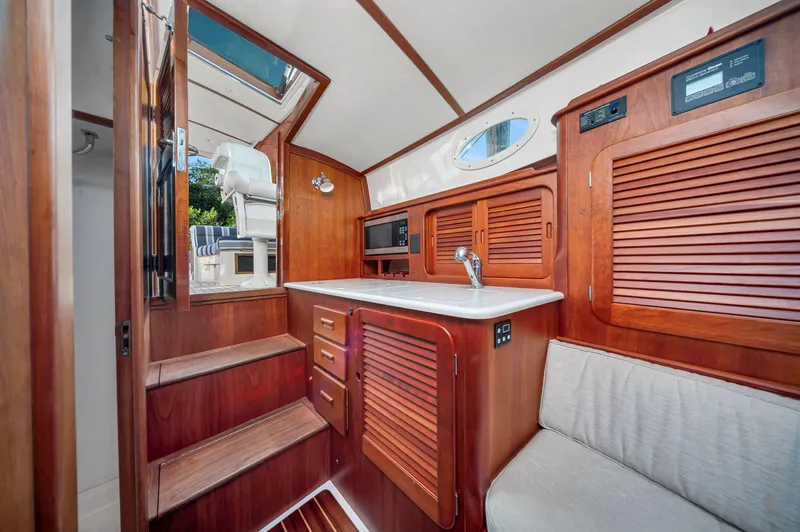 Midnight Yacht Photos Pics 2014 Hinckley Picnic Boat 37 MKIII interior with wooden cabinetry and seating.