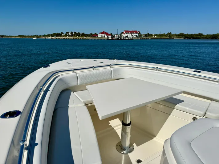  Yacht Photos Pics 2020 Cobia 350 Center Console boat with table, scenic waterfront view.