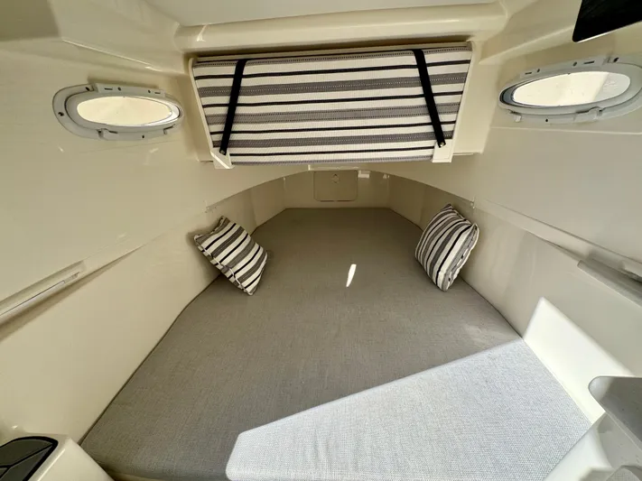  Yacht Photos Pics 2020 Cobia 350 Center Console cabin interior with striped pillows and portholes.