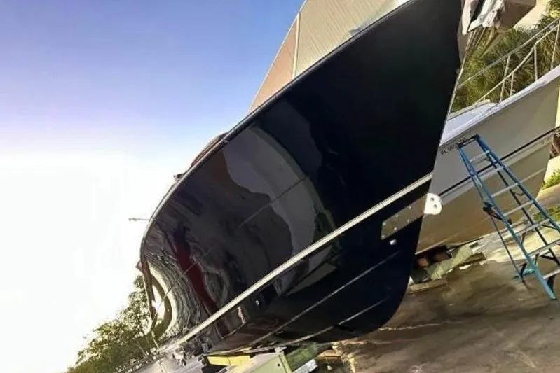  Yacht Photos Pics 2019 Scout 420 LXF boat on dry dock, sleek black hull, sunny day.