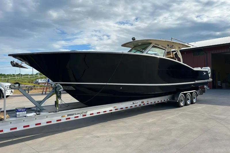  Yacht Photos Pics 2019 Scout 420 LXF boat on trailer, parked outdoors under cloudy sky.