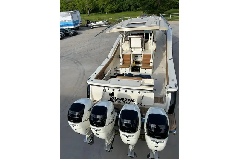  Yacht Photos Pics 2019 Scout 420 LXF boat with four powerful outboard engines, docked on concrete.