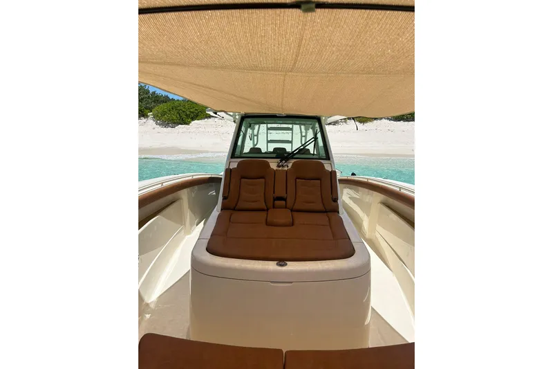  Yacht Photos Pics 2019 Scout 420 LXF boat interior with sunshade, anchored near a sandy beach.