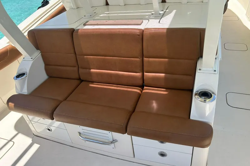  Yacht Photos Pics Brown leather seating on 2019 Scout 420 LXF boat, featuring cup holders and storage.