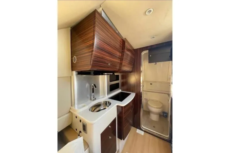  Yacht Photos Pics Interior of 2019 Scout 420 LXF boat featuring compact kitchen and bathroom area.