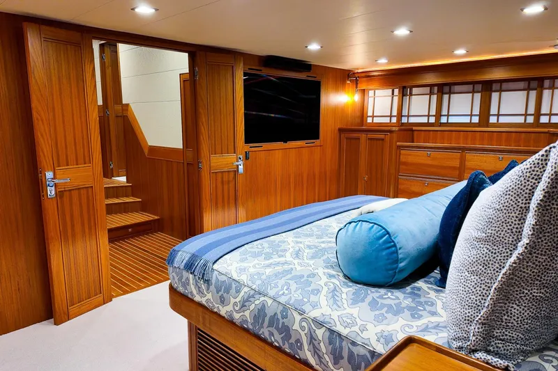 Top Times Yacht Photos Pics Luxurious Marlow Voyager Series 2022 yacht interior with elegant wood paneling and cozy bedding.