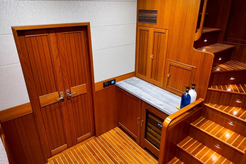 Top Times Yacht Photos Pics Luxurious wooden interior of 2022 Marlow Voyager Series yacht with elegant cabinetry and staircase.