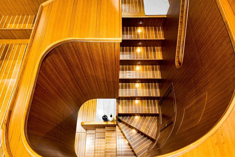 Top Times Yacht Photos Pics Luxurious wooden staircase on 2022 Marlow Voyager Series yacht, featuring elegant lighting.