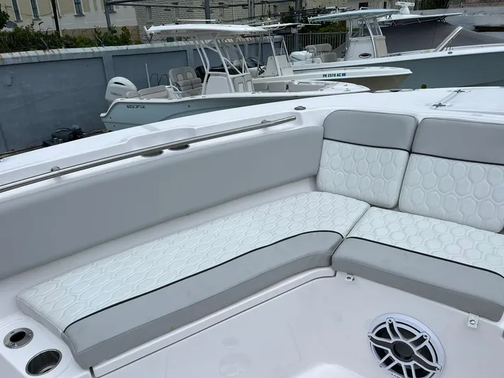  Yacht Photos Pics 2023 Sea Fox 328 Commander boat interior with white cushioned seating and speaker.