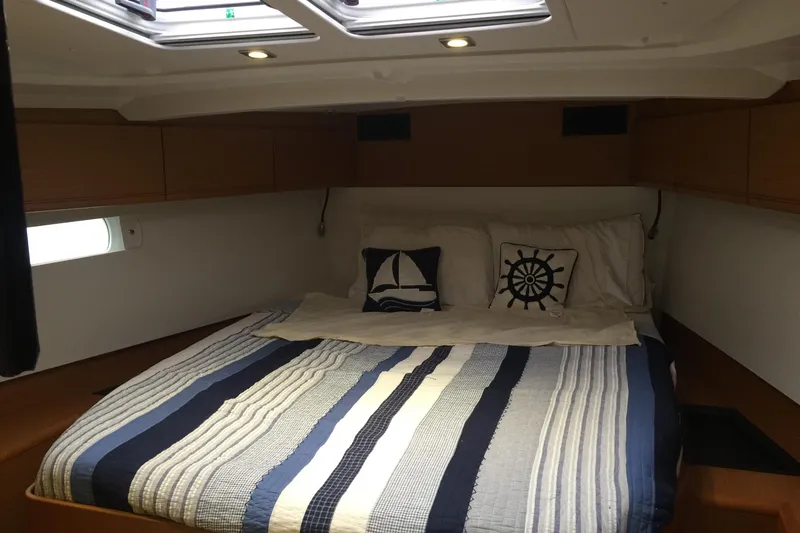  Yacht Photos Pics Cozy cabin interior of 2012 Jeanneau Sun Odyssey 509 with nautical-themed bedding.
