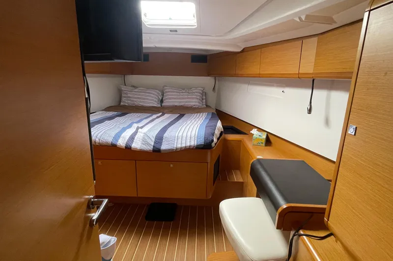  Yacht Photos Pics Interior cabin of 2012 Jeanneau Sun Odyssey 509 yacht with bed and seating area.