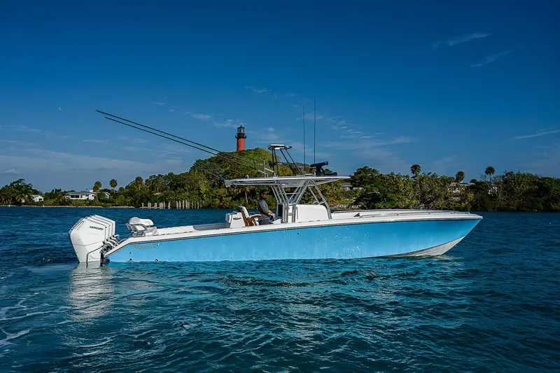 T/t Waterfront Yacht Photos Pics 2013 Bahama Quad V10's boat on blue water with lighthouse in background.