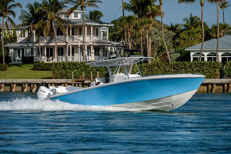 T/t Waterfront Yacht Photos Pics 2013 Bahama Quad V10's boat cruising near waterfront homes with palm trees.