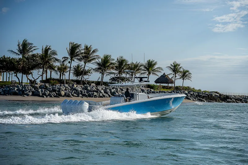 T/t Waterfront Yacht Photos Pics A 2013 Bahama Quad V10's boat cruising near a tropical shoreline with palm trees.