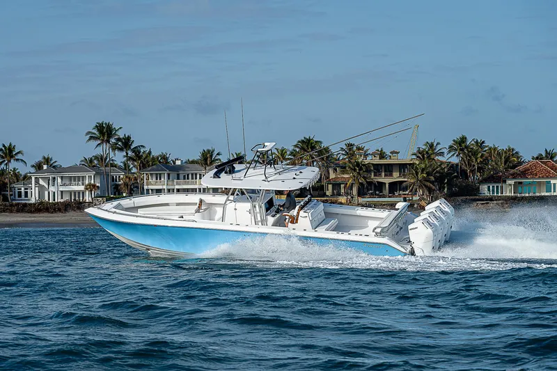 T/t Waterfront Yacht Photos Pics 2013 Bahama Quad V10's boat cruising near coastal homes, clear blue water.