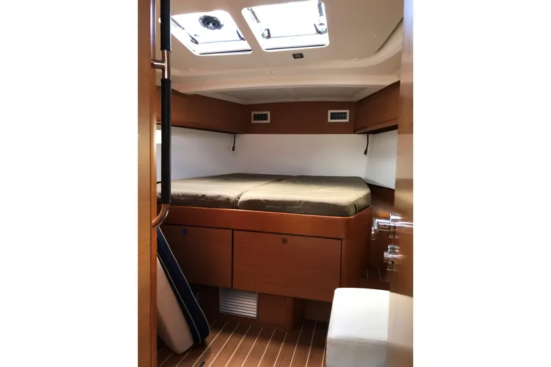 Northern Lights Yacht Photos Pics Interior cabin of 2015 Jeanneau Sun Odyssey 469 sailboat, featuring a cozy bed and wooden finish.