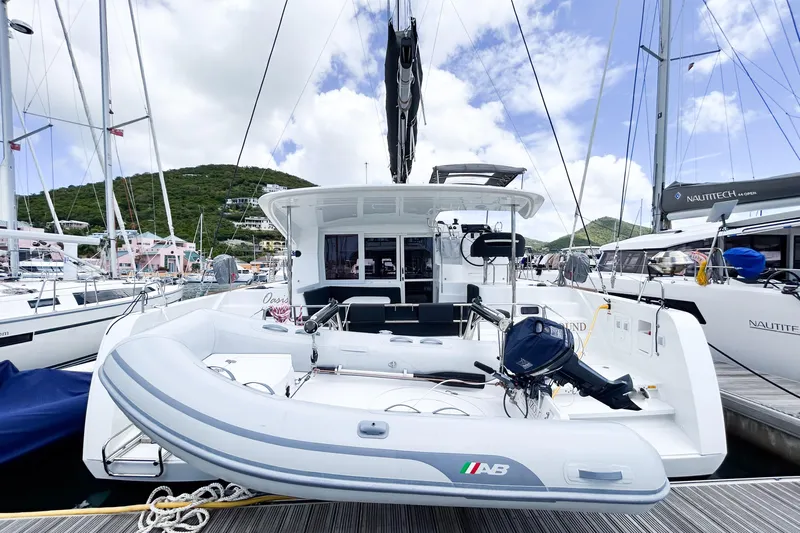 Oasis Yacht Photos Pics 2025 Lagoon 40 catamaran docked with inflatable boat, surrounded by other yachts.