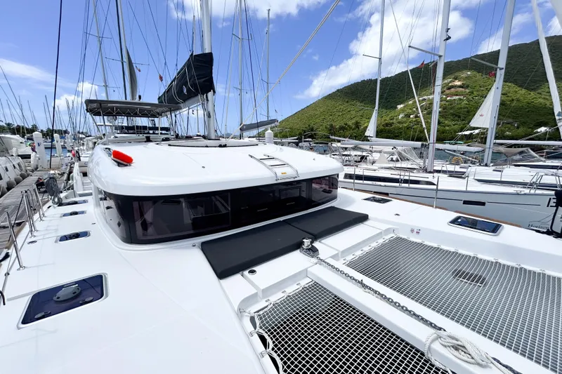 Oasis Yacht Photos Pics 2025 Lagoon 40 catamaran docked at marina, surrounded by sailboats, under clear blue sky.