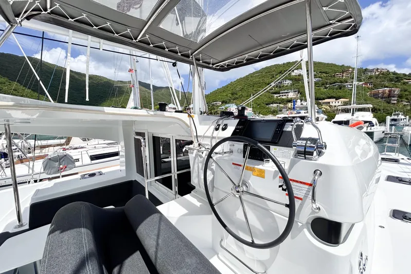 Oasis Yacht Photos Pics 2025 Lagoon 40 yacht helm station with scenic marina backdrop.