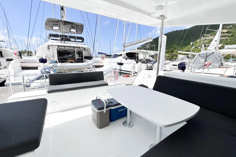 Oasis Yacht Photos Pics Modern Lagoon 40 catamaran interior, 2025 model, docked with other yachts in a scenic marina.