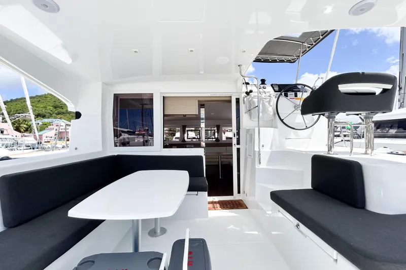 Oasis Yacht Photos Pics 2025 Lagoon 40 catamaran interior with seating area and helm, featuring modern design.