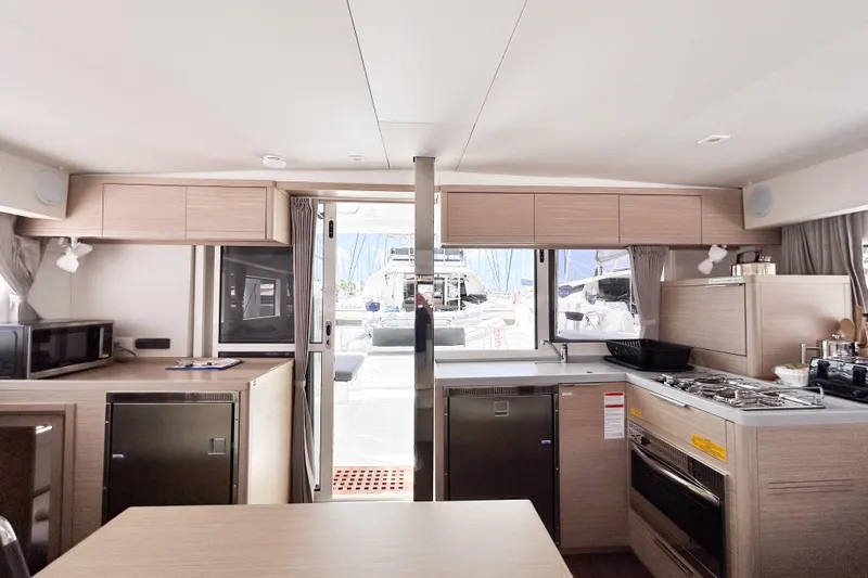 Oasis Yacht Photos Pics Modern interior of 2025 Lagoon 40 catamaran with kitchen and dining area.