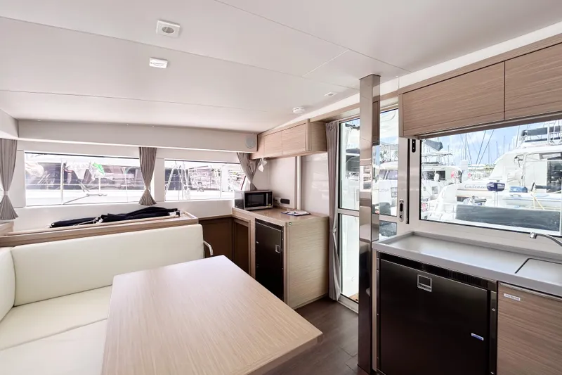 Oasis Yacht Photos Pics Modern interior of 2025 Lagoon 40 catamaran with sleek kitchen and dining area.