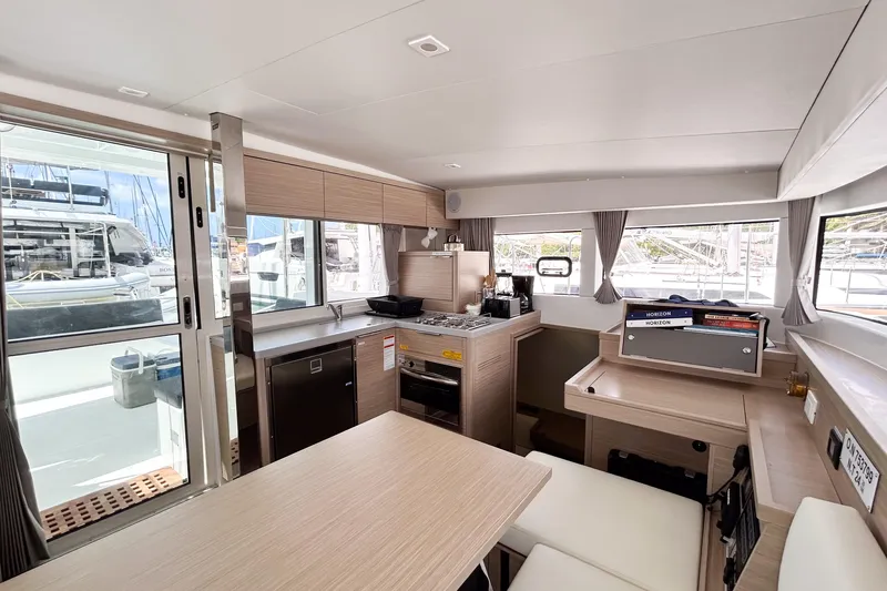 Oasis Yacht Photos Pics Modern interior of 2025 Lagoon 40 catamaran with kitchen and dining area.