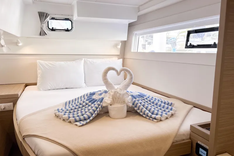 Oasis Yacht Photos Pics Luxurious cabin interior of 2025 Lagoon 40 catamaran with elegant towel swan decoration.