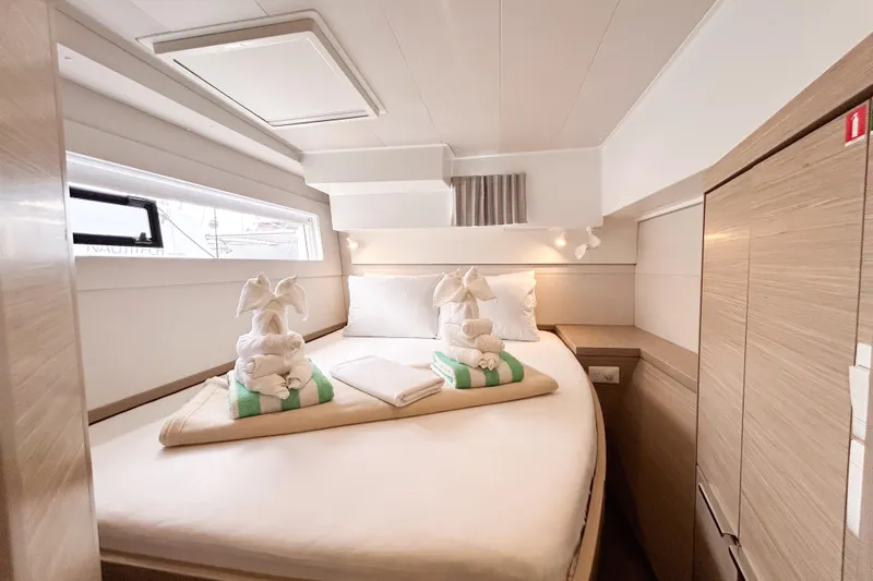 Oasis Yacht Photos Pics Luxurious cabin interior of 2025 Lagoon 40 catamaran with elegant bedding and towel art.