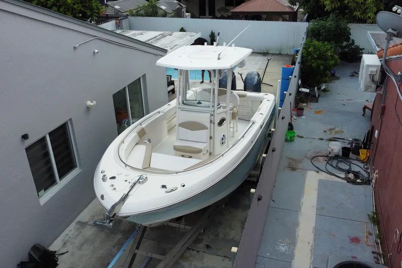  Yacht Photos Pics 2018 Robalo R242 Center Console boat parked in a narrow driveway.