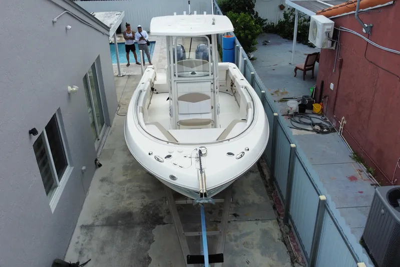  Yacht Photos Pics 2018 Robalo R242 Center Console boat parked in a narrow driveway.