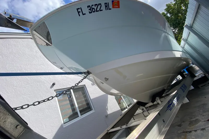  Yacht Photos Pics 2018 Robalo R242 Center Console boat on trailer, parked near a building.