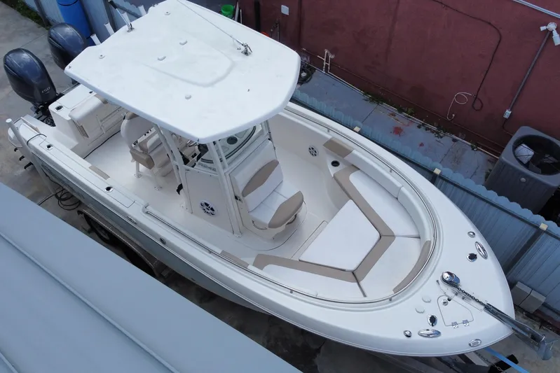  Yacht Photos Pics 2018 Robalo R242 Center Console boat with dual engines, docked in a yard.
