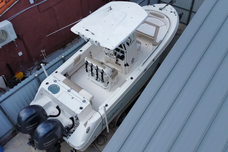  Yacht Photos Pics 2018 Robalo R242 Center Console boat with dual Yamaha engines, docked in a sheltered area.