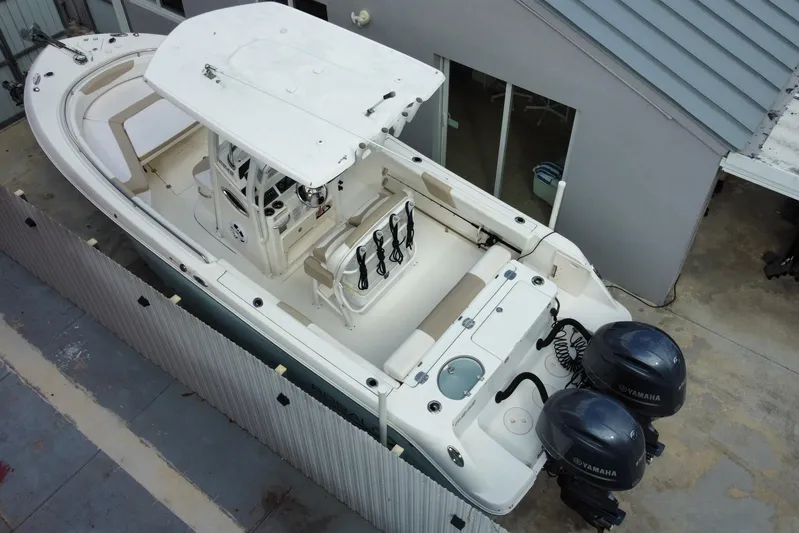  Yacht Photos Pics 2018 Robalo R242 Center Console boat with dual Yamaha engines, docked beside a building.