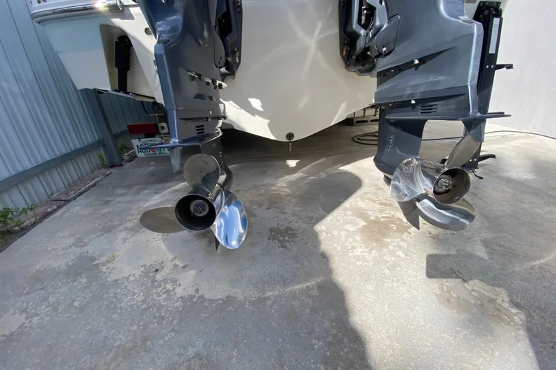  Yacht Photos Pics 2018 Robalo R242 Center Console boat with dual outboard motors and shiny propellers.